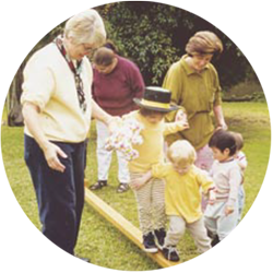1980s image of carers helping children walk on balance beam