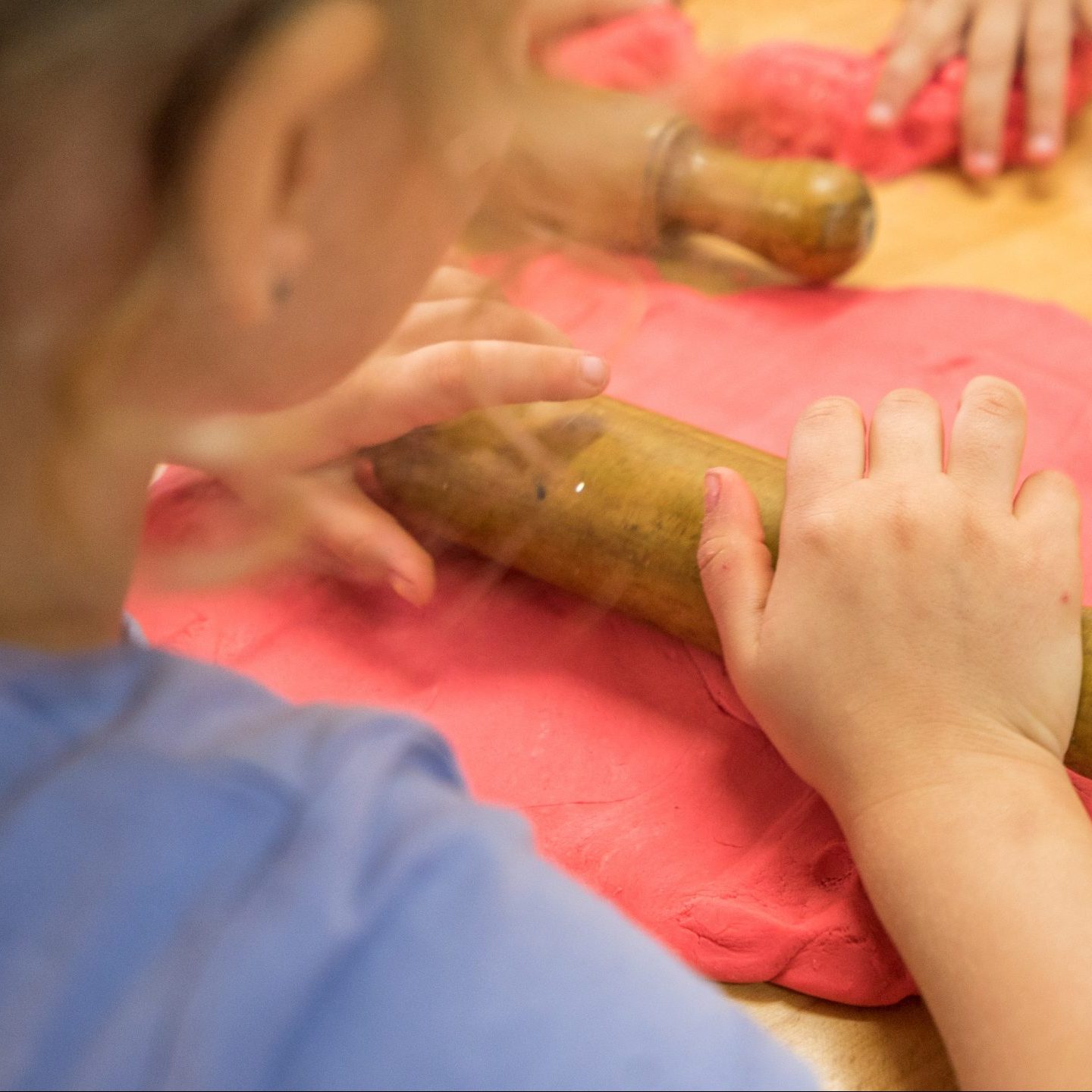 little girl rolling clay dough