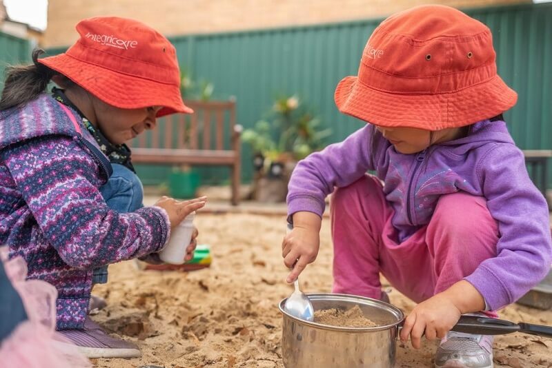 Two girls playing with sand